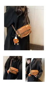 Detailed view of the brown woven leather shoulder bag with exquisite hardware and cute charm.