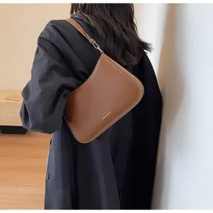 Details of brown leather baguette shoulder bag, minimalist design, elegant underarm daily wear.