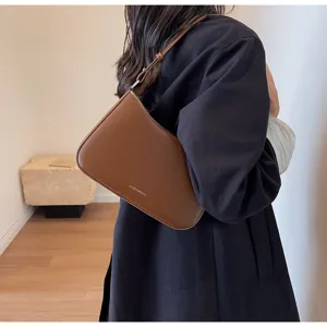 Brown vintage baguette bag detail shot, chic minimalist leather shoulder bag for women.