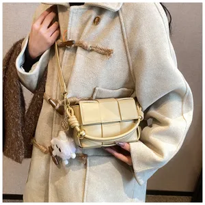 Detail view of the beige woven leather crossbody handbag, showcasing intricate intrecciato design.