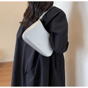 Asymmetrical baguette shoulder bag, minimalist light blue leather design with sleek metal hardware.