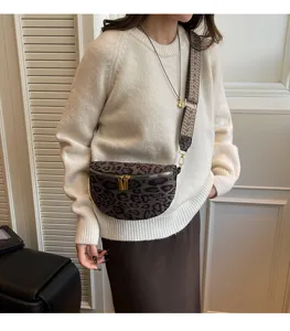 Leopard print chest bag detail showcasing wide patterned strap and dual gold zippers.
