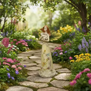 Detail view of the resin garden fairy statue holding a cute animal on stone path.