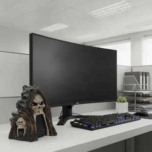 Close-up detail view of the resin skull grim reaper solar lamp on office desk, spooky decor.