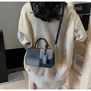 Detail view of the stylish color-blocked handbag worn on shoulder, showing textured fabric.