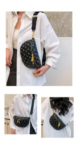 Detailed view of fashionable black patterned chest bag with wide strap and gold hardware.