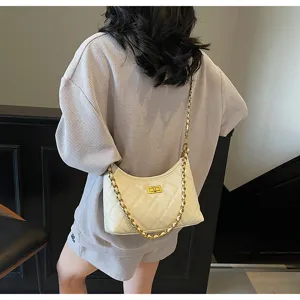 Detailed view of women's quilted shoulder bag with gold chain strap and chic turn lock.