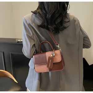 Detailed back view of women color-blocked retro shoulder bag with handle and chic tag.