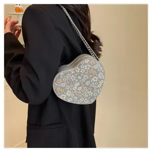 Detailed close-up view of the heart-shaped floral bag showing pattern and chain strap.