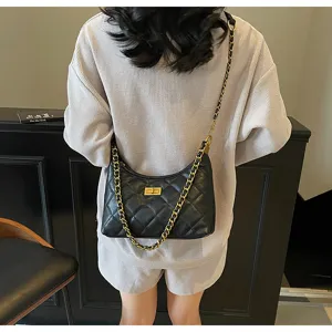 Detail view of the black quilted shoulder bag with gold chain strap and elegant turn-lock design.