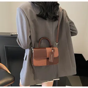Detailed view of women retro color-blocked shoulder bag, showing contrast texture and strap.