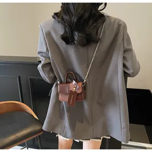 Detail view of stylish color-block small square bag with chain strap and handle for women.