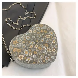 Heart-shaped crossbody bag for women with sparkling floral pattern and chic metal chain strap.