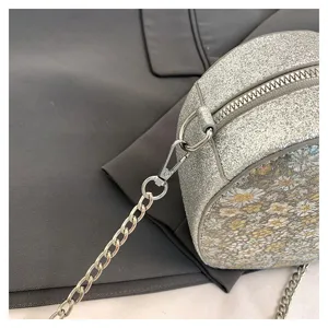 Silver glitter crossbody bag detail, stylish floral pattern women shoulder bag design.