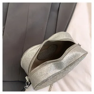 Silver glitter heart-shaped crossbody bag detail, sparkling chain shoulder bag for women.