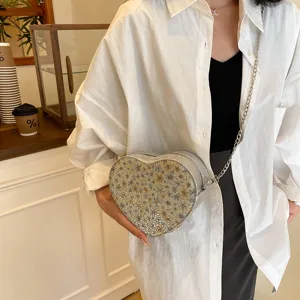 Stylish heart-shaped crossbody bag with chain strap and sparkling rhinestone finish.