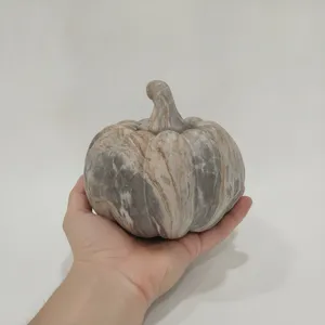 Resin pumpkin ornament detail, showing marble texture and hand scale for home decor.