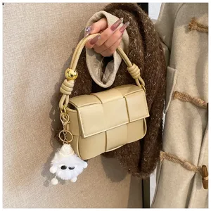 Detailed view of the stylish beige woven leather handbag showing fine craftsmanship and charm.