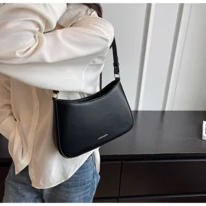 Close-up detail of black leather shoulder underarm baguette bag with silver hardware.