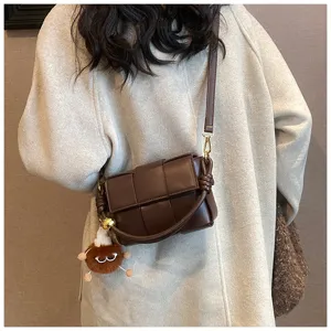 Brown woven leather crossbody bag with knot detail and cute plush charm for women daily use