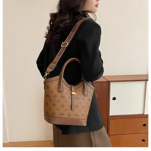 Detail view of stylish brown bucket bag with classic monogram pattern and shoulder strap.