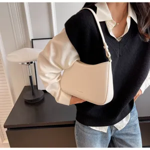 Detailed view of a chic minimalist shoulder bag worn by a model in a stylish interior.