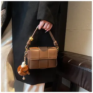 Brown woven shoulder bag PU leather small square handbag with plush charm and chic gold ball.