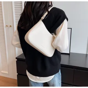 Detail shot of the elegant white baguette shoulder bag showcasing minimalist underarm design.