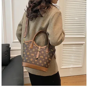 Vintage brown monogram bucket bag for women, stylish leather trim shoulder handbag.