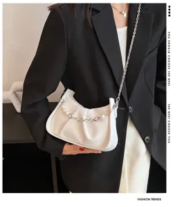 Vue détaillée de l'élégant sac bandoulière blanc plissé avec chaîne perlée et design chic.