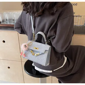 Light blue PU leather handbag with embossed pattern, golden hardware and cute pink keychain.