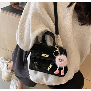 Black top handle shoulder bag with chic hardware and cute plush charm for women daily wear.