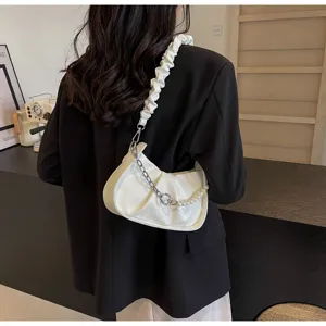 Detailed shot of the white ruched shoulder bag featuring a chic gathered strap and pearl chain.