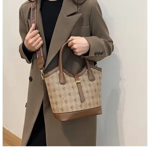 Detailed view of women's vintage bucket handbag, stylish brown monogram pattern shoulder crossbody.