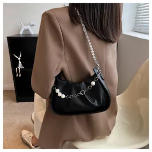 Gros plan détaillé d'un sac bandoulière plissé noir tendance avec une lanière de perles.