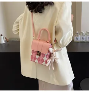 Detailed view of pink plaid mini crossbody shoulder bag with cute bunny charm and metal lock.