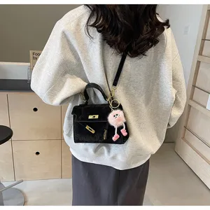 Fashion black velvet embossed Kelly bag for women, chic top handle crossbody bag with plush charm.