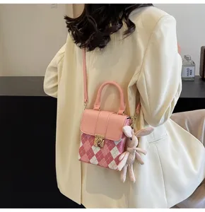 Trendy pink plaid shoulder bag for women, cute phone messenger bag with rabbit plush pendant.