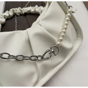 Detail shot of white pleated shoulder bag with elegant pearl strap and chunky metal chain.