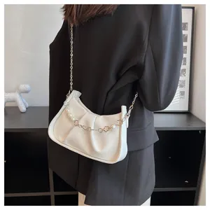 Vue détaillée d'un sac bandoulière plissé blanc avec chaîne en perles porté par le mannequin.