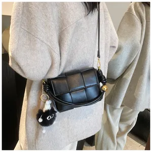 Black woven leather shoulder crossbody bag with plush charm, stylish chic winter women handbag.