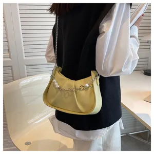 Vue détaillée d'un sac bandoulière plissé jaune chic avec élégantes lanières de perles et de métal.