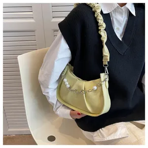 Gros plan détaillé de l'élégant sac porté épaule plissé jaune clair avec bandoulière en perles.