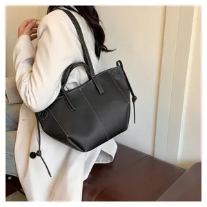 Detail view of stylish black leather tote bag, large capacity, versatile shoulder handbag.