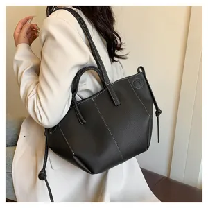 Black leather tote bag with white contrast stitching and side knots, stylish shoulder bags.