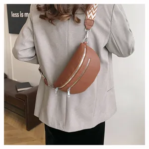 Vue détaillée de la pochette de poitrine en similicuir marron tendance avec large sangle et zips.
