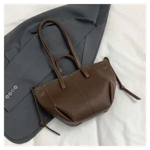 Detailed shot of the brown leather shoulder bag featuring stylish side knots and sturdy dual handles.