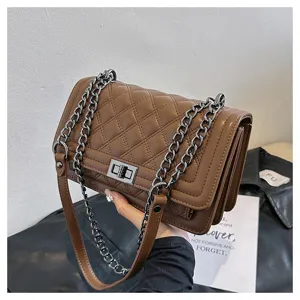 Detailed view of the stylish brown quilted shoulder bag with chain strap and metal lock.