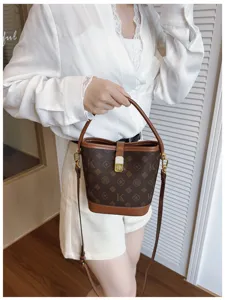 Vintage monogram bucket bag for women with top handle and crossbody strap, retro style.