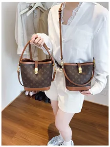 Retro monogram bucket bag featuring brown canvas, leather trim and secure metal lock closure.